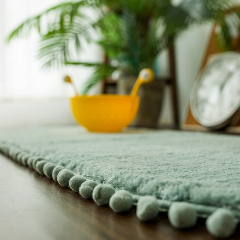 Tapis ovale antidérapant orné de pompons