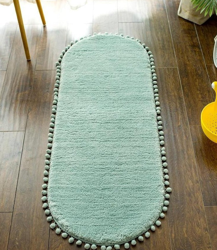 Tapis ovale antidérapant orné de pompons