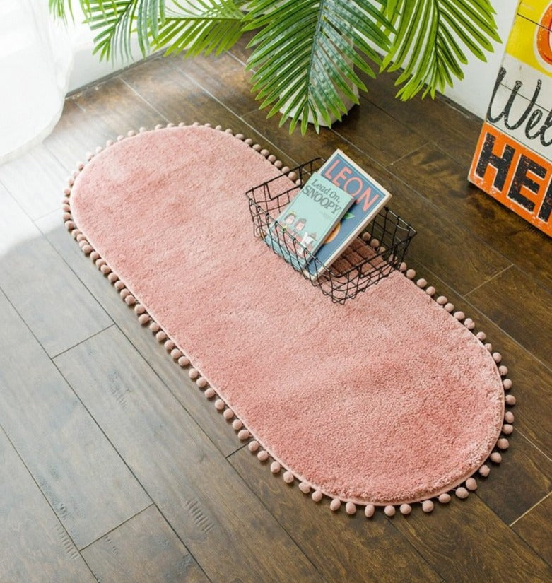 Tapis ovale antidérapant orné de pompons