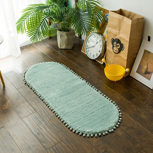 Tapis ovale antidérapant orné de pompons