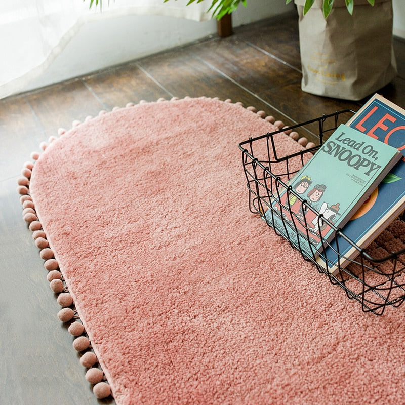 Tapis ovale antidérapant orné de pompons