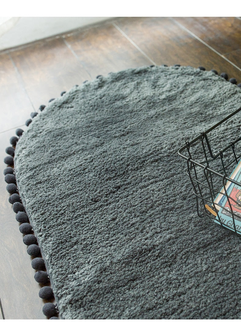 Tapis ovale antidérapant orné de pompons