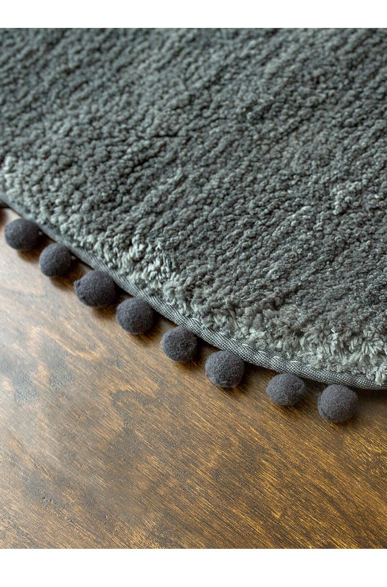 Tapis ovale antidérapant orné de pompons