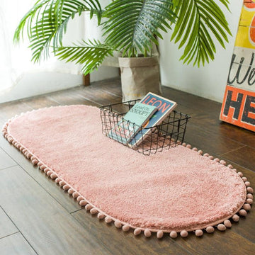 Tapis ovale antidérapant orné de pompons
