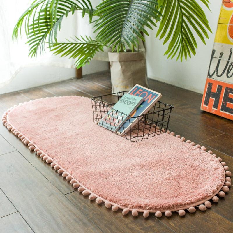 Tapis ovale antidérapant orné de pompons